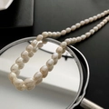 Barock-Reisperlenarmband mit natürlichem cremeweißem Glanz auf einer Spiegelfläche - Titanstahl Perlenkette (06-K6)