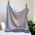 Blue paisley silk scarf displayed on wooden hangers with a stylish white handbag - 70x70cm / Blue