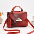 Détail du sac à main rouge motif crocodile avec fermoir doré et poignée ronde élégante - Rouge