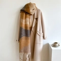 Thick winter scarf with wide earth-tone stripes and long tassels styled on a wool coat - Caramel color