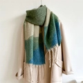 Detail of a thick color block scarf with long tassels on a camel wool coat - Olive Green
