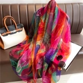Châle en soie luxueux avec imprimé artistique multicolore drapé sur un canapé en cuir - Imprimé Plumes Colorées (YRS63-1)