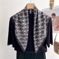 Detail of floral geometric square scarf draped over a black top and pleated green skirt - Grey Geometric Floral (FR42-1)