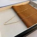 Collana girocollo dorata con ciondoli a cuore lucidi su un vassoio da esposizione - Oro