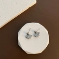 Pendientes de loto plateados con nácar blanco sobre un soporte de exhibición blanco - Plateado