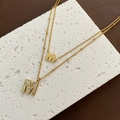 Collana a doppio strato in acciaio al titanio dorato con ciondoli lettera M e madreperla - Collana M in Acciaio al Titanio Oro