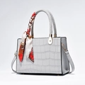 Elegant light grey crocodile texture handbag with woven handles and silk scarf detail - Gray