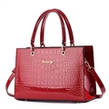 Bolso de mano en piel charol rojo oscuro con relieve de cocodrilo y detalles dorados - Burdeos