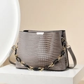 Sac à main taupe gaufré crocodile avec chaîne dorée présenté sur support studio - Khaki