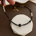 Elegant black beaded choker necklace with white pearls and gold accents on a display stand - Titanium Steel Black Beaded Necklace