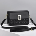 Classic black quilted crossbody bag with elegant gold metal lock on white stand - Black