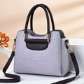 Bolso lila claro con efecto piel de cocodrilo, asas marrones y detalles dorados - Patrón de Cocodrilo Gris