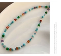 Primer plano de collar de cuentas de piedra natural de colores y cierre dorado - Collar de Acero de Titanio Aguamarina