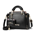 Black PU leather handbag with cute cat charm and gold hardware on white background - Black