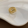 Goldener Schlangenring aus Edelstahl mit grünen Edelsteinaugen auf weißem Tablett - Gold