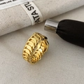 Macro shot of gold wide chain ring featuring layered U-shaped links on canvas background - Gold