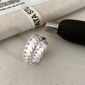 Macro detail of silver woven chain ring with polished metallic industrial texture - Silver