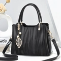 Schicke schwarze Handtasche mit Wellentextur, Goldbeschlägen und Blatt-Perlenanhänger - Schwarz
