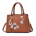 Braune Lederhandtasche mit Blumenstickerei und Bogenanhänger in Karamell-Finish - Erdgelb