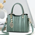 Elegante mintgrüne Handtasche mit Wellentextur und Blattanhänger im schicken Design - Hellgrün