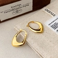 Primo piano di orecchini a cerchio a goccia placcati in oro 18K con finitura lucida - Oro