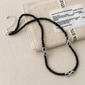 Close-up of black faceted beaded necklace with three silver bow charms and lobster clasp - Black Beaded Bowknot Necklace