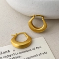 Vue détaillée de boucles d'oreilles créoles irrégulières en métal doré mat brossé - Or