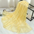 Detailed close-up of yellow chiffon scarf texture hanging on a black metal rack - Light Yellow