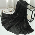 Detail shot of black glitter shawl fabric with shimmer fibers and elegant wave texture - Black