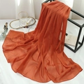 Close-up of orange pleated chiffon scarf with fine gold silk glitter and rolled hem edge - Brown
