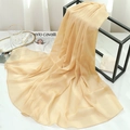 Close-up of pleated champagne chiffon scarf with subtle shimmer on a stylish metal rack - Light Khaki