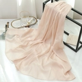 Close-up of pleated soft pink chiffon scarf draped on a black metal display stand - Apricot