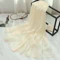 Detail of cream-colored chiffon scarf with pearlescent texture on a display stand - Off-white