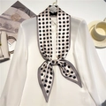 Close-up of champagne polka dot silk scarf tied in a bow on a white shirt collar - Champagne Gold Black Polka Dot (LE-185)