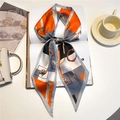 Detailed close-up of a narrow silk scarf tied in a bow on a white book with vintage patterns - Vintage Chain Fan Patchwork (LE-188)