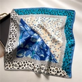 Detail showing mixed animal print and floral patterns on silk scarf with smooth texture - Blue
