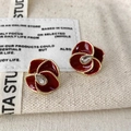Dettaglio orecchini a fiore in smalto rosso con bordo perlato dorato e zircone centrale - Smalto a Fiore Rosso Bordeaux