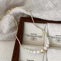 Detail of elegant gold necklace with gradient pearls displayed on a luxury jewelry stand - Gold
