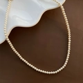 Élégant collier de perles blanches à un rang présenté sur une assiette en céramique - Blanc Crème (Petit)