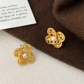 Detailed close-up of gold filigree flower earrings with white pearls and small zircons - Gold