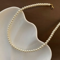 Collier de perles crème élégant avec fermoir doré sur une assiette blanche ondulée chic - Blanc Crème (Moyen)