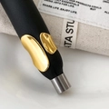 Macro detail of high-shine gold asymmetric open ring on a black leather display pedestal - Gold