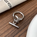 Detail of silver T-bar drop earrings with polished finish on a rustic wood surface - Silver