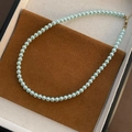 Élégant collier de perles vert menthe avec fermoir doré sur support en daim brun - Bleu Glacé (Moyen)
