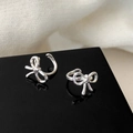 Set di ear cuff a fiocco argento con design minimalista lucido su base in acrilico - Orecchino a Clip a Fiocco Lato Sinistro