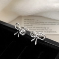 Orecchini a fiocco in argento minimalista su velluto nero per un look elegante - Orecchino a Clip a Fiocco Lato Destro