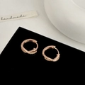 Dettaglio degli orecchini a cerchio incrociati in oro rosa con zirconi su espositore - Oro rosa