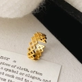 Close-up of golden geometric hollow ring with diamond mesh and adjustable open band - Gold