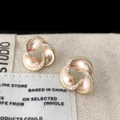Dettaglio macro di orecchini a trifoglio in oro rosa con zirconi e finitura opaca - Orecchini a Bottone in Smalto Champagne