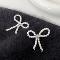 Elegant pearl bow earrings featuring center cubic zirconia on a plush black background - Bowknot Stud Earrings